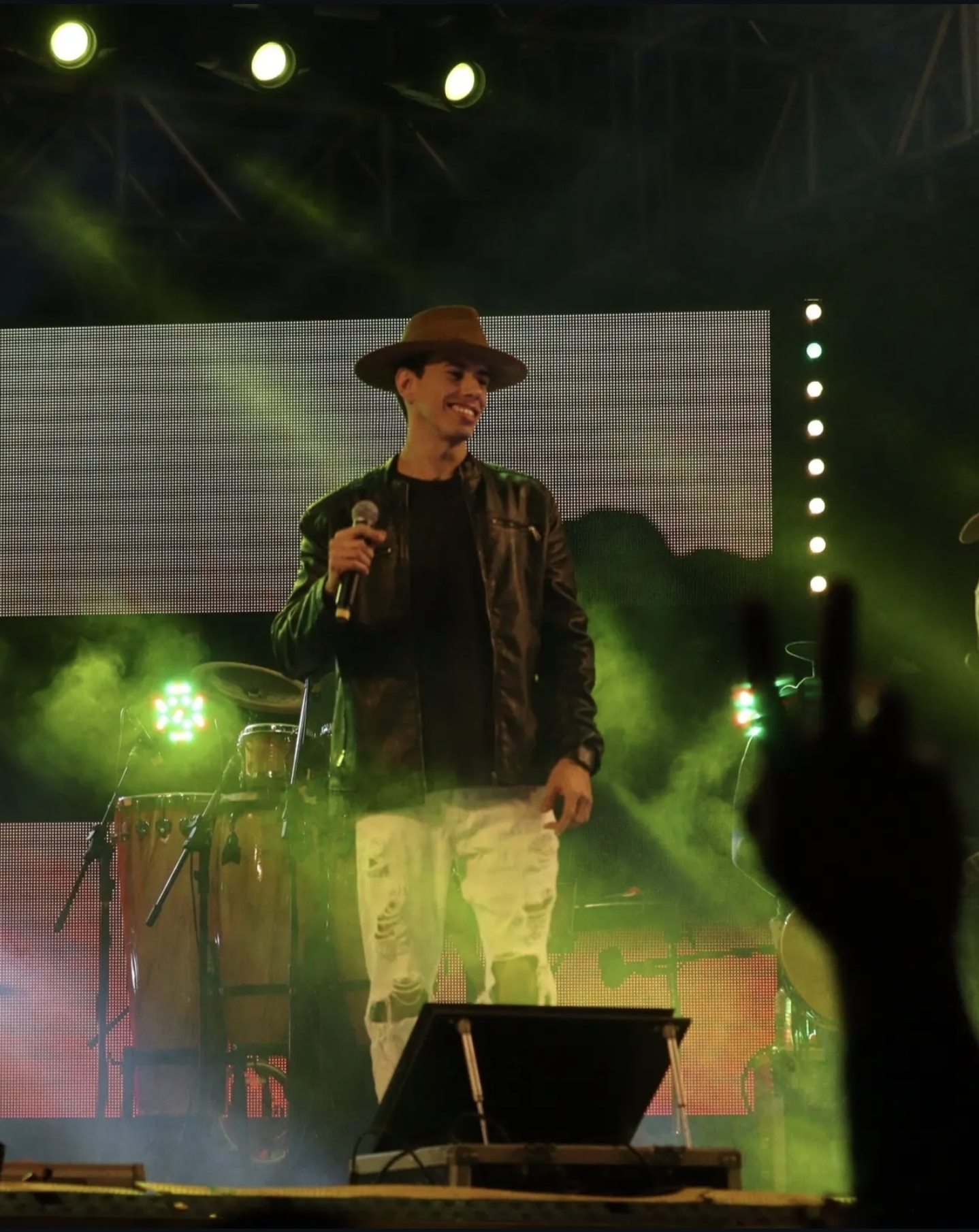 Anderson Junior sorrindo entre as luzes do palco