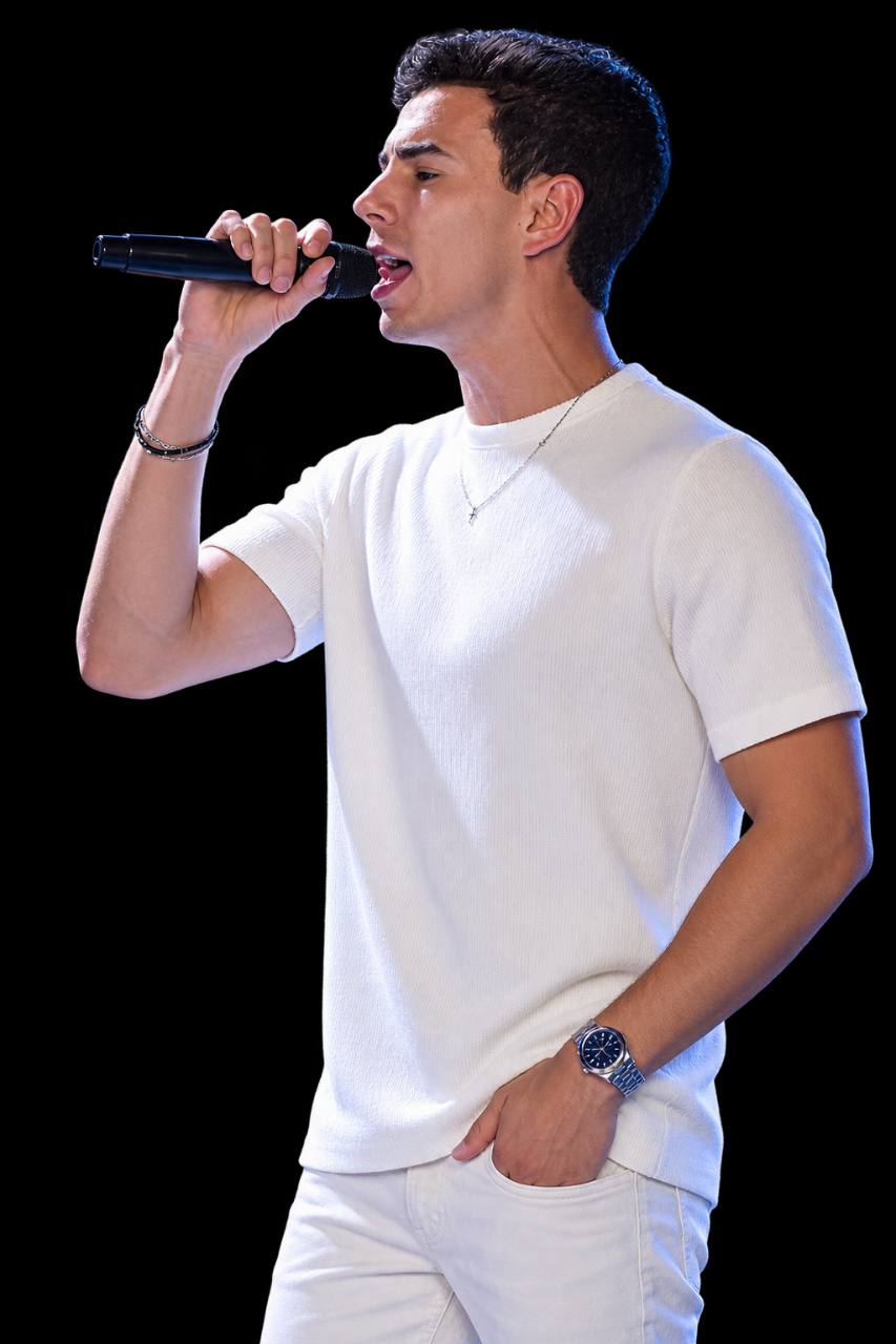 Anderson Junior vestido de branco cantando ao microfone